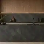 Modern kitchen featuring dark grey Formica laminate sheets on cabinets, backsplash, and island surface.